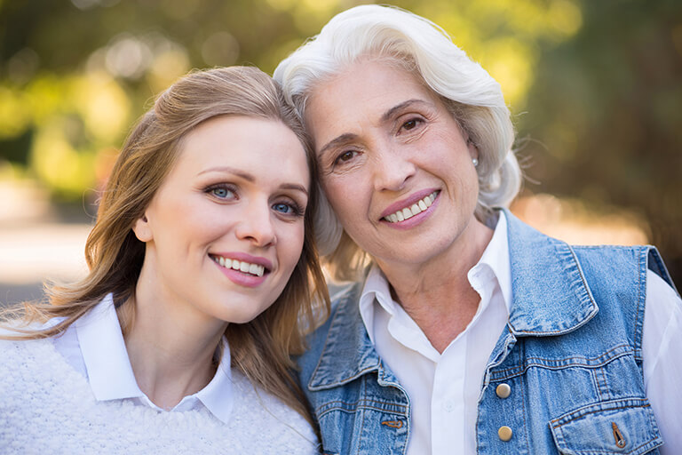 A young woman with her head next to an older woman